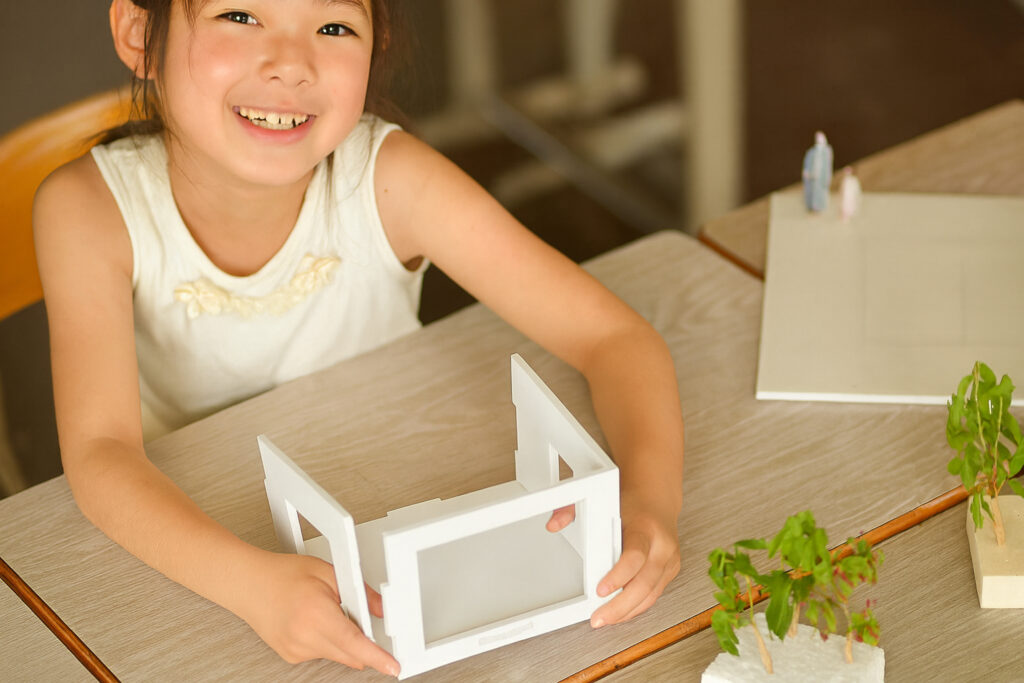 間取り模型を使った家づくりワークショップを楽しむ子ども